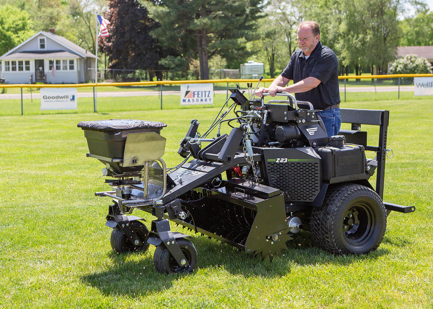 Force overseeding attachment used on baseball or softball field turf 