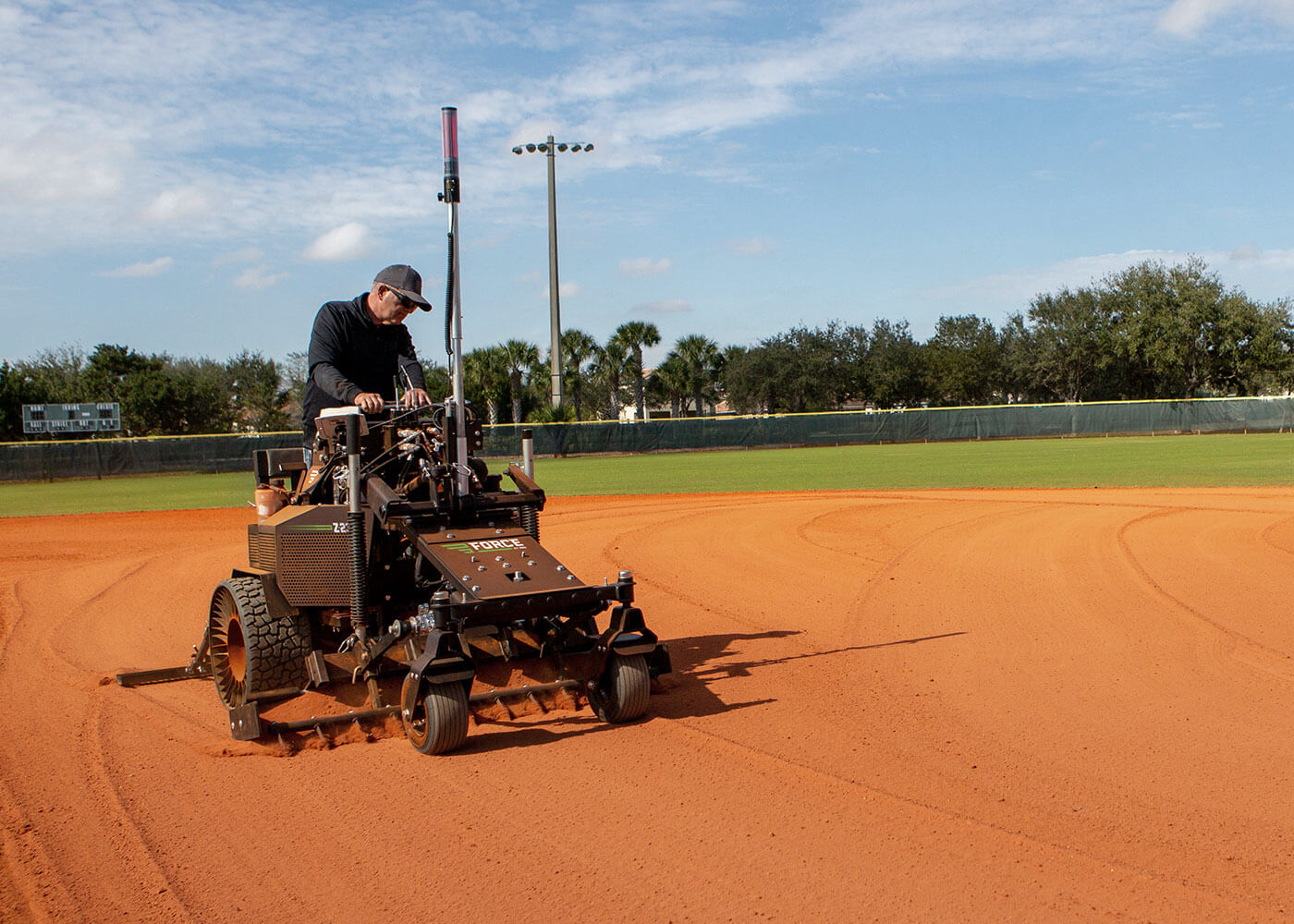 Force precision laser grading smoothing over weather damage on baseball field 